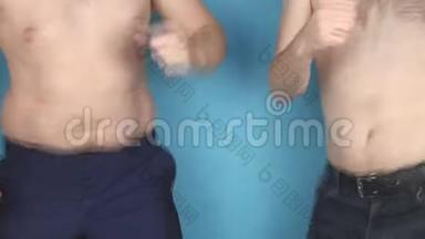 两个赤胖肚子的男人在蓝色背景下跳舞，肥胖和不健康的饮食观念，慢潮
